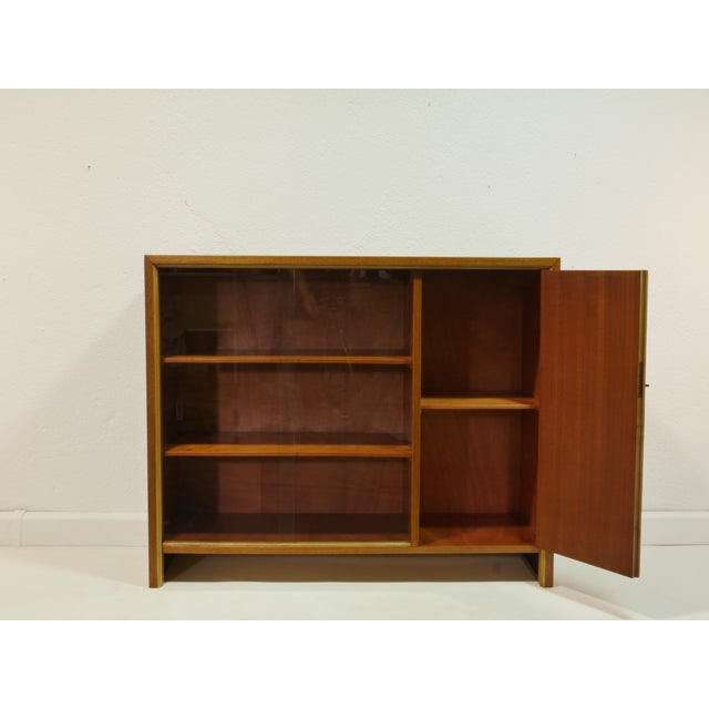 This elegant vintage bookcase from the 1950s combines functionality with classic mid-century design. The warm look of the...