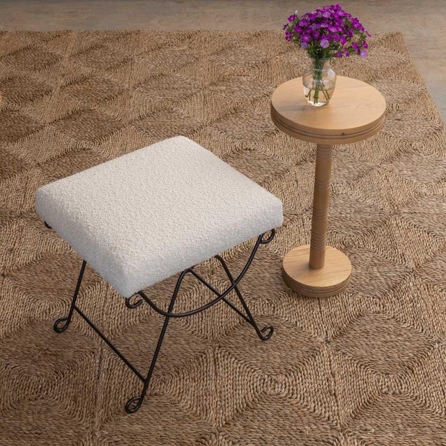 Iron stool with beautiful curved and looped base with matte black painted finish. Rectangular cushioned seat upholstered...