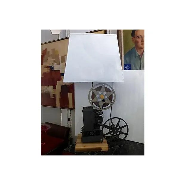 A one of a kind, custom made lamp made using a mid-century movie projector placed on a wood base. New working wiring. Uses...