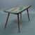 For sale is a coffee table with a typical 1950s mosaic pattern.