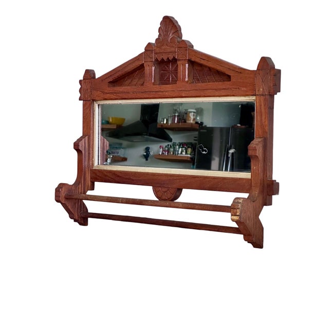 This striking antique wall mirror features a solid wood frame with classic Eastlake-style detailing, including geometric...