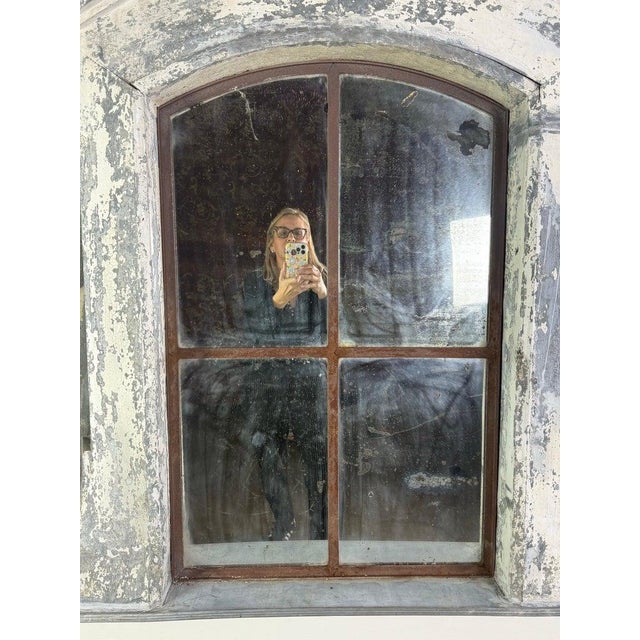 A striking architectural mirror fashioned from an antique dormer window frame, exuding authentic European charm and a...