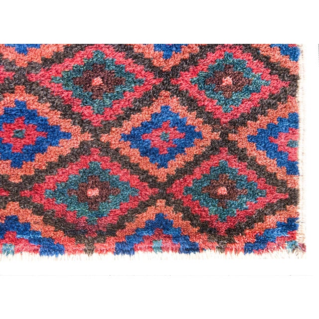 This petite early 20th-century Persian Baluch rug is a striking example of tribal craftsmanship, woven by the Baluch...