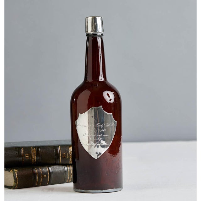 Wonderful, rare antique golf award decanter with a sterling silver award plaque and opening. The amber glass decanter...