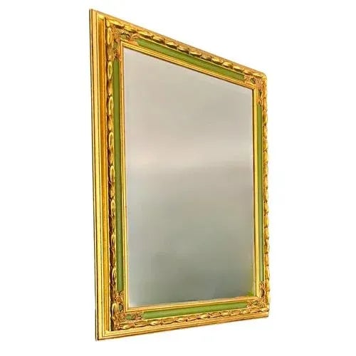 A fantastic large Empire style mirror in gilded wood and gesso with green accents, decorated with stylized foliage friezes...
