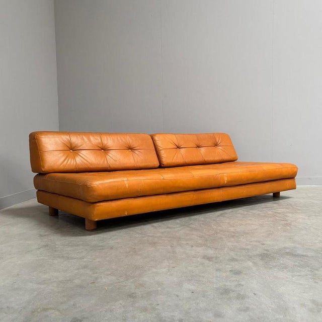 Remarks: Vintage leather daybed / sofa, Germany 1960s. Wooden frame and upholstered with soft cognac leather. Sofas is in...