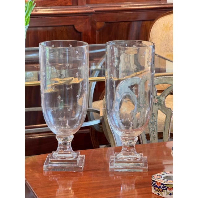 Clear glass vases with elongated forms and etched star decoration, each raised on stepped square bases. Elegant and...