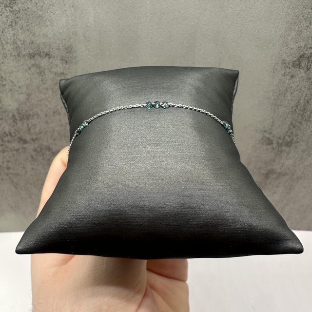 This elegant drilled diamond station bracelet in 14kt white gold features 0.80 carats total weight of natural irradiated...