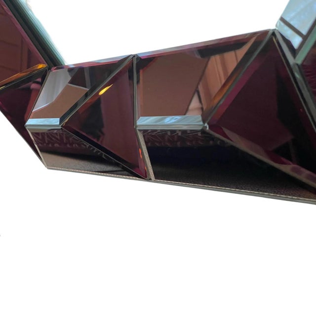 A striking wall mirror by Bungalow 5, model Romano. Featuring an amethyst-colored faceted frame, it combines bold geometry...