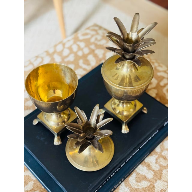 Beautiful vintage pair!! This is a stunning pair of midcentury brass pineapple urns. These have a footed base. These are...