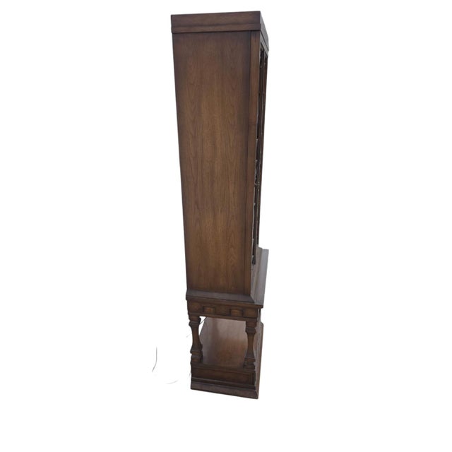 Elegant iron and glass display cabinet featuring decorative wrought iron scrollwork and glass shelving. Crafted with a...