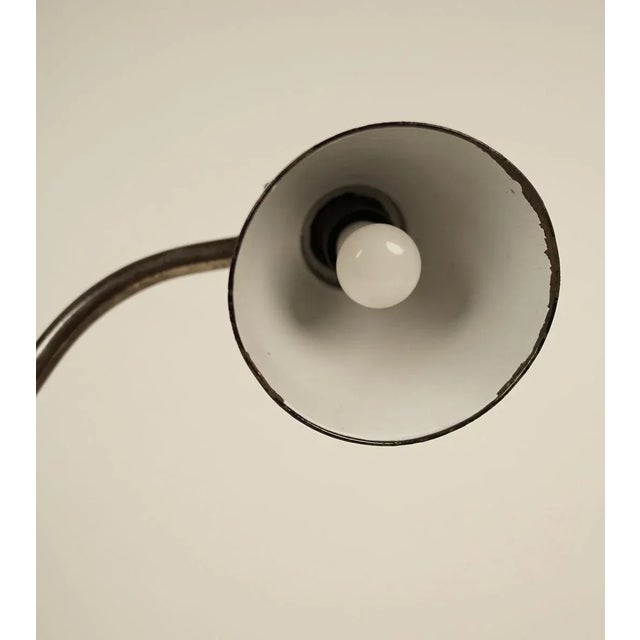 Clamp mounted industrial table lamp that was made in the 1930s. It is constructed from enameled black and white steel with...