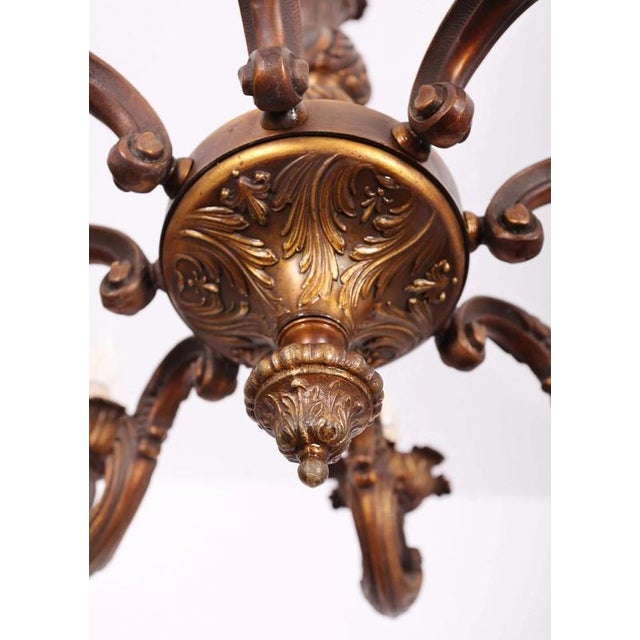 High-quality chandelier made of patinated metal with rich floral decor. The chandelier is sturdy. Restored electrical...
