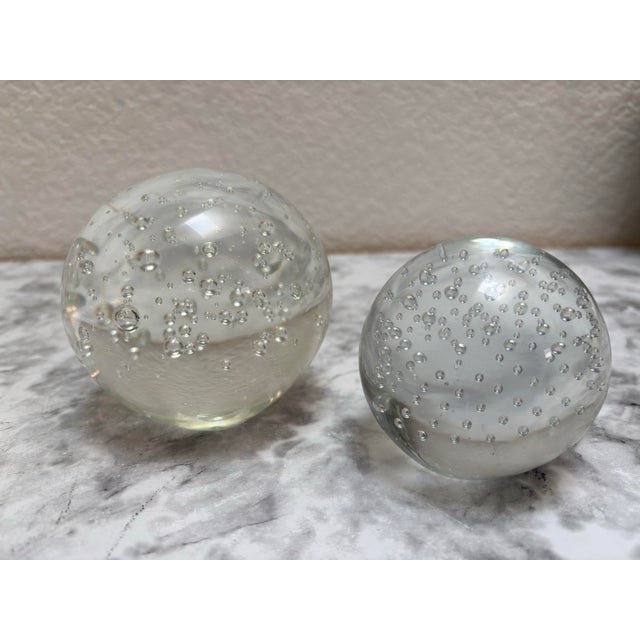 Set of two solid glass ball bubble paperweights- one smaller and one larger. Effervescent clear glass design. Smaller one...