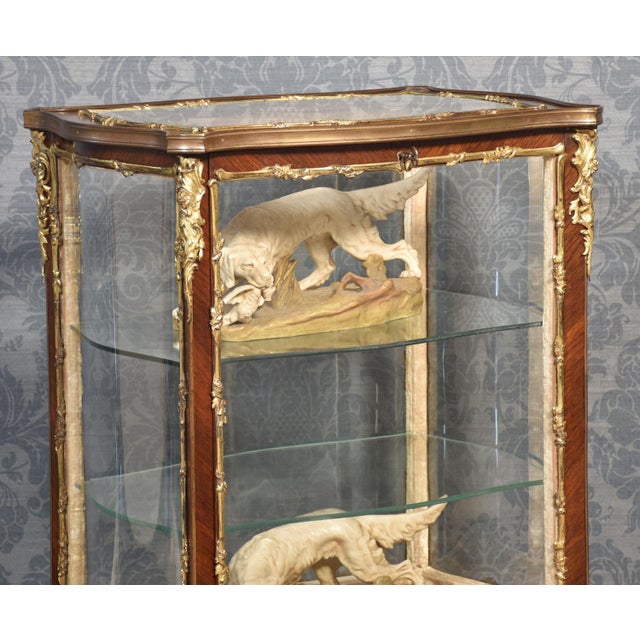 French walnut bijouterie cabinet of Louis XVI design, of serpentine form decorated with gilt metal mounts. The bevelled...