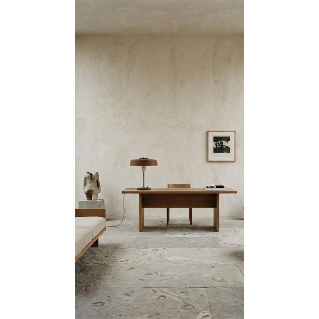 An elegant table lamp inspired by the design language of Dutch designer Louis Kalff, a key figure in European modernist...