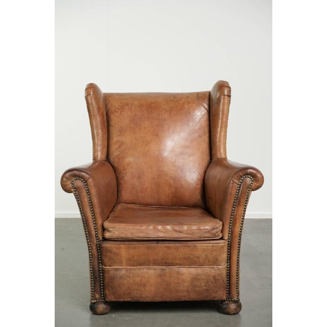 This charming vintage sheepskin wingback chair is crafted in a luxurious English style. The chair features a removable...