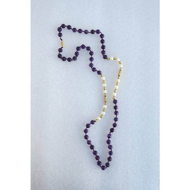 A beautiful bead necklace comprised of cultured pearls, purple amethyst beads, 14-karat gold beads (in two shapes),...