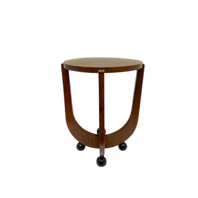A stunning 1920s Art Deco “Amsterdam School” sculptural side table featuring a round wooden top resting on an elegant,...