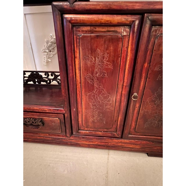 Antique chinese hardwood display cabinet having a pierced gallery top above stepped shelves and supported by turned...