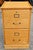 A Late 20th Century Oak Two-Drawer Legal Size Filing Cabinet with lock. Will hold legal size and letter size file folders....