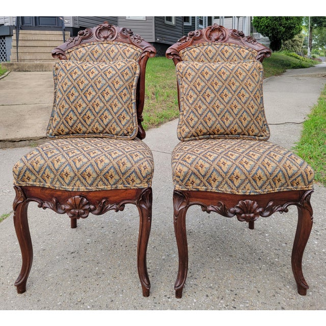 This pair of exquisitely carved Victorian parlor chairs features rosewood frames and tapestry weave upholstery with a...