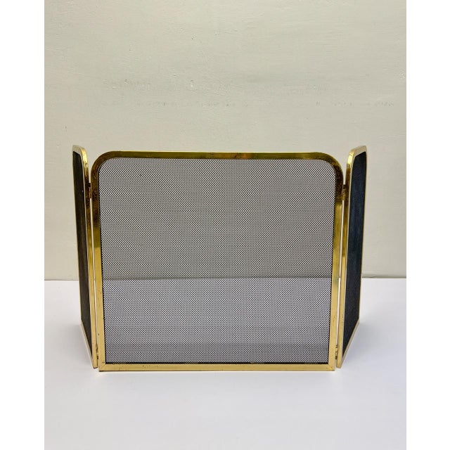 A 1970s brass and mesh triptych screen for protection fire spitting from the fireplace. It is in good vintage condition...