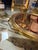 Elegant round Italian serving tray featuring a smoked mirrored surface, a polished brass frame, and sculptural side...