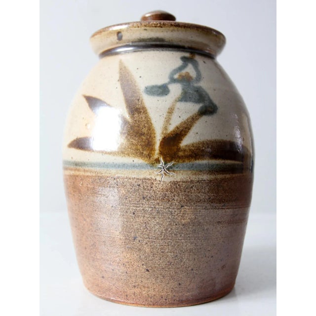 This is a vintage studio pottery jug vase. The hand-crafted pottery features a warm beige and brown speckled glaze with...