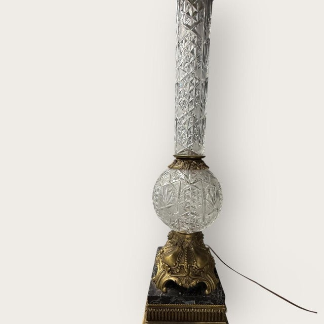 A grand-scale Hollywood Regency table lamp defined by a towering column of heavy, hand-cut crystal in a diamond quilted...
