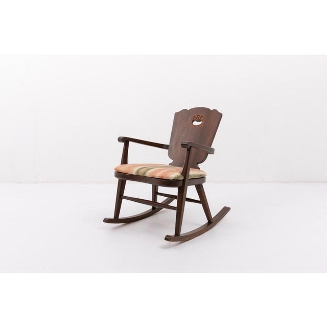 Mid-Century rocking chair produced in Sweden, 1950s. Stained solid pine structure with a loose seat cushion pad. Condition...