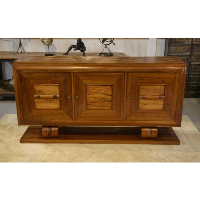A 1940s sideboard with a solid design, in the late Art Deco/Brutalist style, with a striking architectural presence. The...
