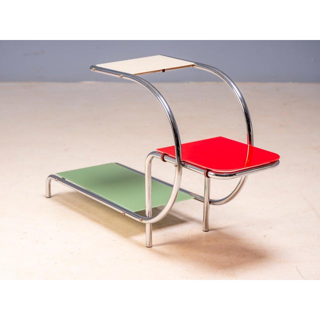 An elegant vintage flower stand designed by Emile Guyot, featuring a graceful chrome-plated tubular steel frame fitted...