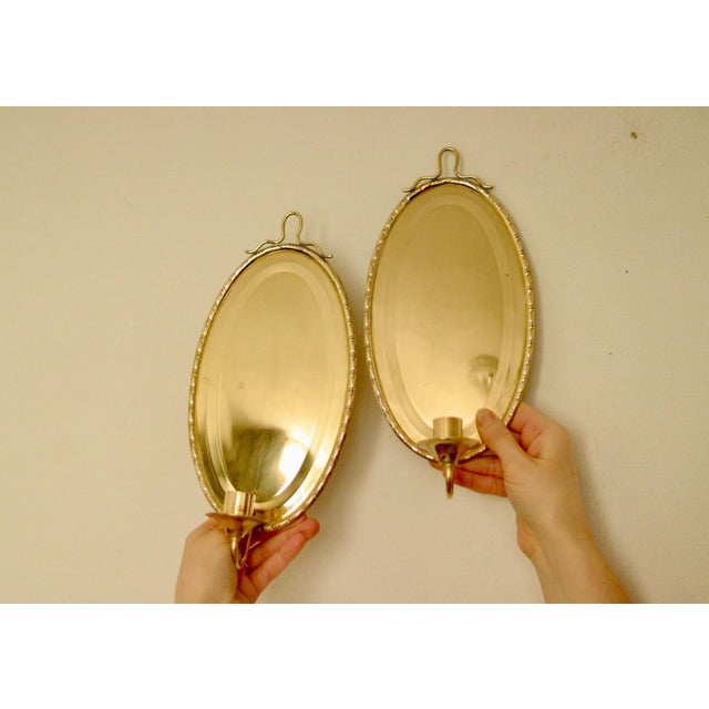 Made in Sweden A breath-taking mid-century duo of exquisite Swedish brass wall sconces in oval shape, Meticulously...