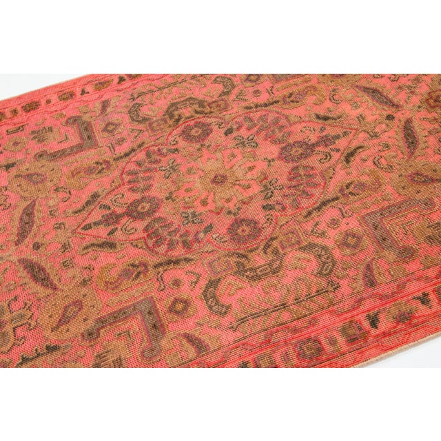 This beautiful scatter rug is hand-knotted from wool in a pink salmon hue, featuring accents of brown, gray, and purple...