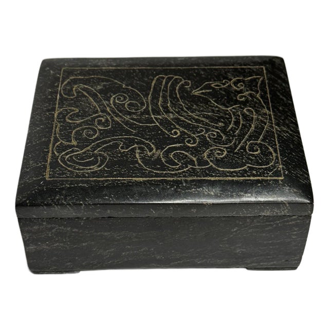 An etched abstract design adorns the lid and contrasts well with the black marble of the piece. Off -white striations are...