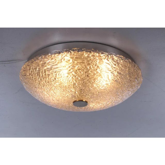 Beautiful glass ceiling lamp made of Murano glass. The fixture is made of metal and has a large lampshade, made of thick-...