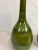 Green vase featuring a crackle glaze and aged green finish with long neck. Hand made items may vary in size, pattern and...
