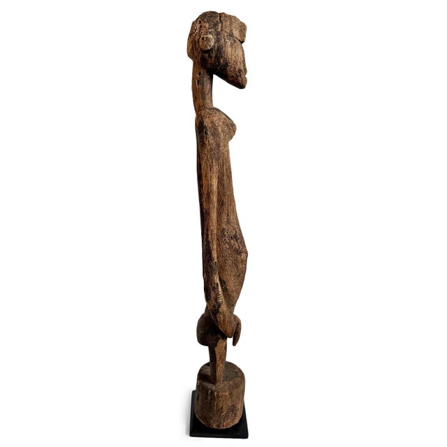Antique Mumuye male figure from Nigeria, masterfully carved in wood with the elongated proportions and openwork arm...