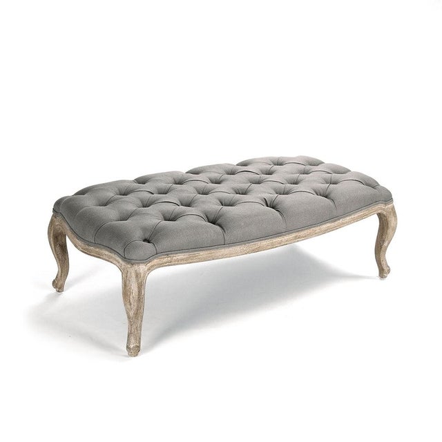 The Maison Tufted Ottoman from Zentique in grey linen features an elongated oval shape with deep button tufting. The...