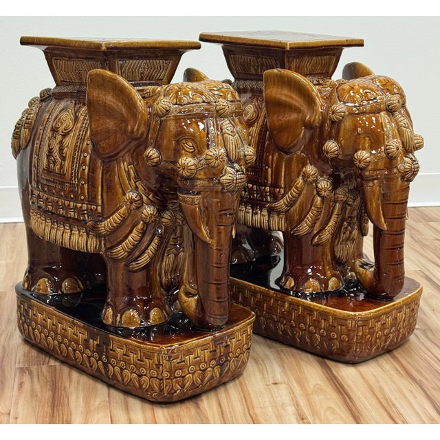 Vintage brown elephant garden stools featuring decorative garb with tasseled headdress and saddle draping. Wonderful...