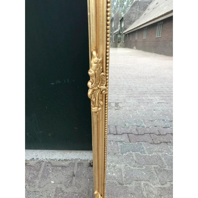 A glamorous pair of 1970 Italian Rococo-style full-length mirrors, beautifully designed with ornate antique gold frames...