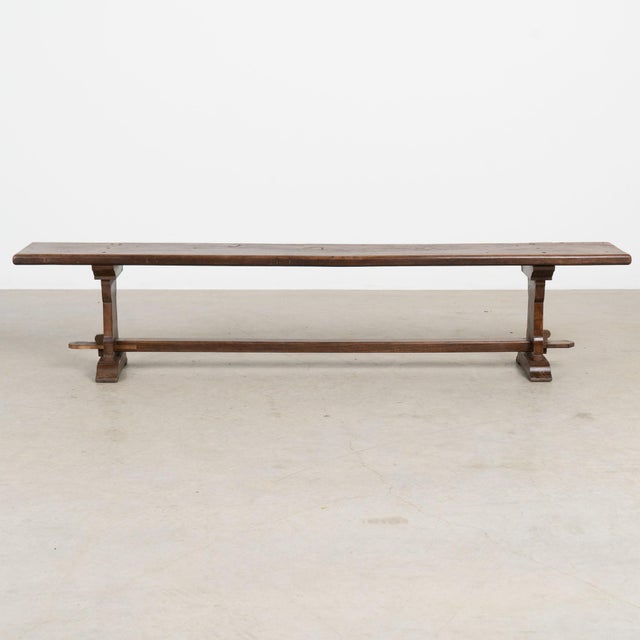 Early 20th century French bench with a simple trestle base and clean, understated lines. The chestnut wood has developed a...