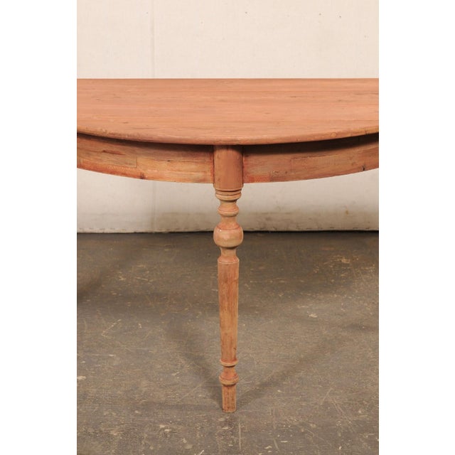 A Swedish carved-wood single demi-lune table from the early 20th century. This antique demi-lune table from Sweden...