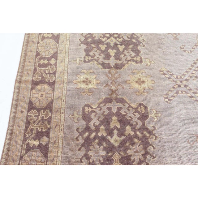 A remarkable example of early 20th-century Turkish weaving, this antique Oushak rug from the 1920s exudes quiet elegance...