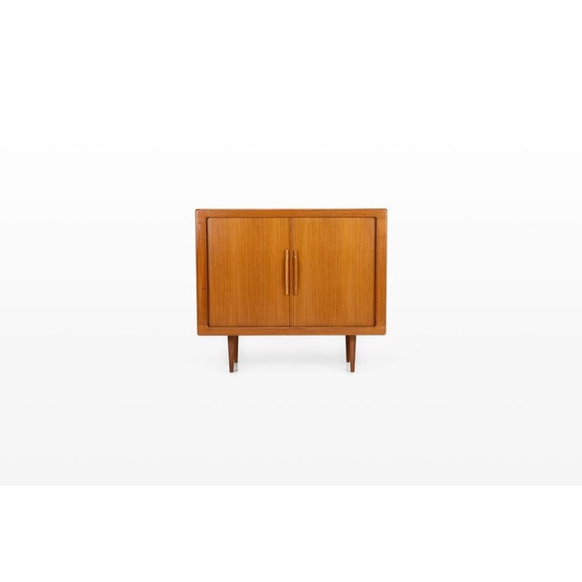 Elegant vintage midboard crafted in teak and produced in Denmark during the 1960s. Featuring characteristic tambour doors,...