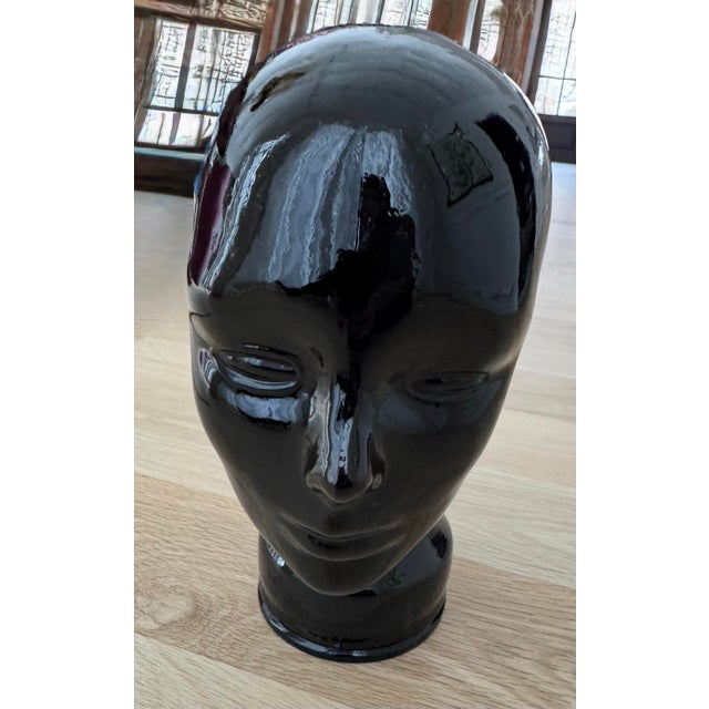 Striking vintage hand-blown black glass mannequin head, attributed to German modernist production, circa 1960s–1970s. This...