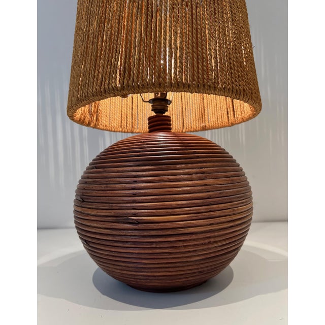 This very nice round table lamp is made of a rattan base with a rope shade. This is a French work in the style of Adrien...