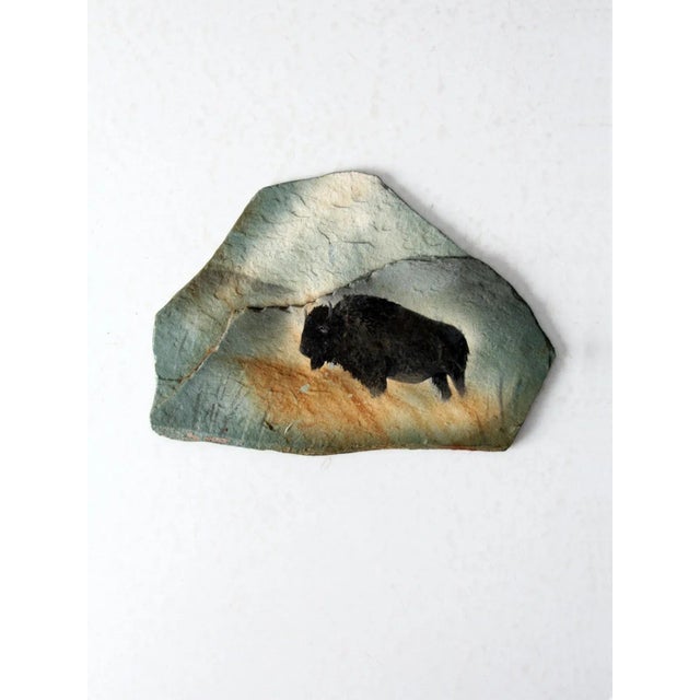 A vintage American bison painting rendered on a natural piece of slate. The hand-crafted artwork captures the bison in...