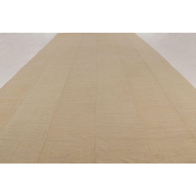 Handwoven in wool circa 1950-1960, this oversized 13x24 Persian kilim is a sophisticated example of minimalist flatweave...